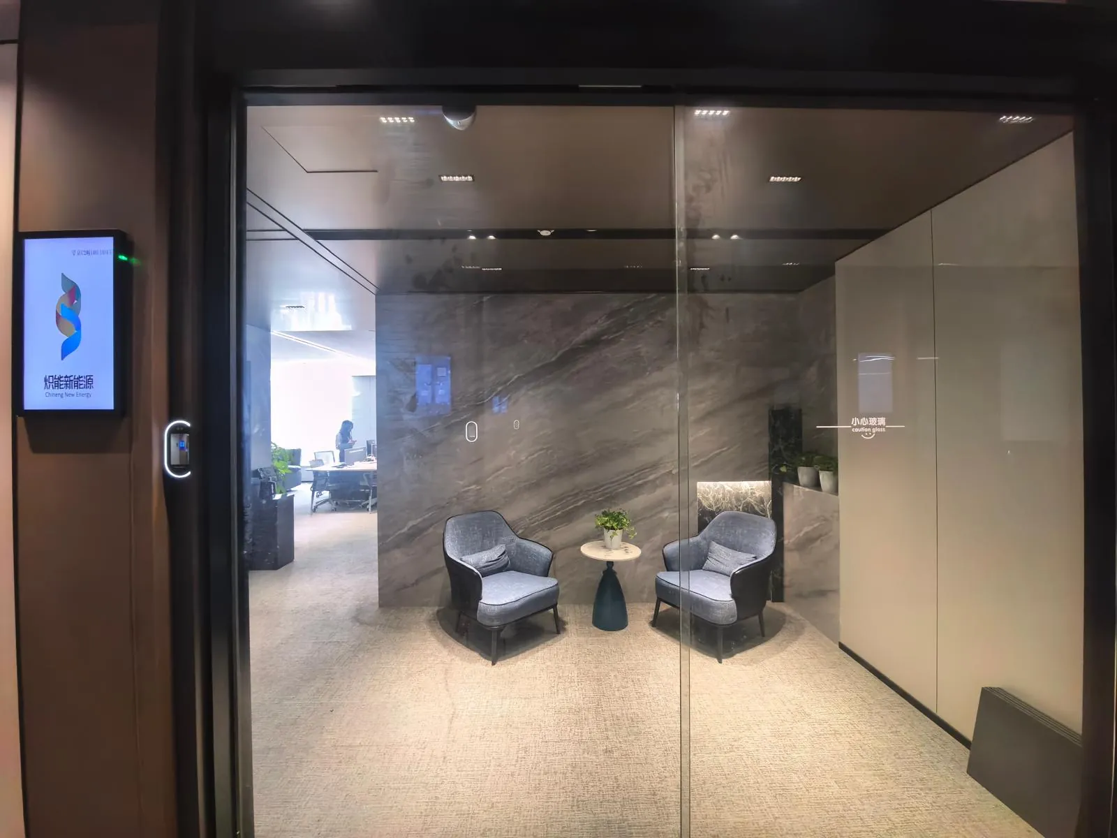 Glass office entrance beside a screen showing the logo and the name Chineng New Energy